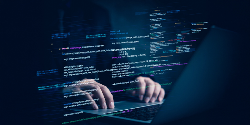Banner image 2 showing a developer coding a website with multiple screens displaying code and design
